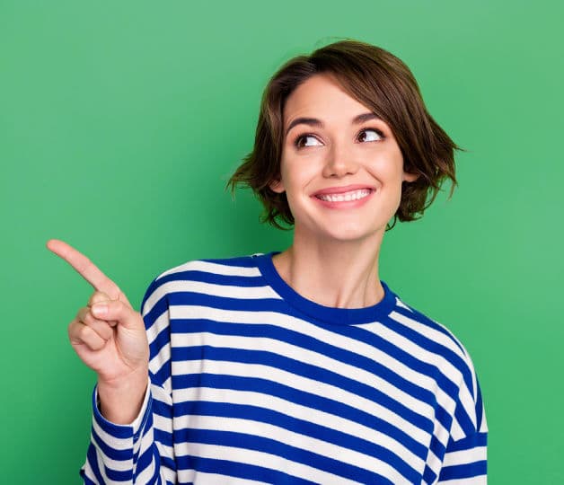 Smiling woman pointing to contact information for JobsinED, a specialist in teaching jobs London and graduate education recruitment.
