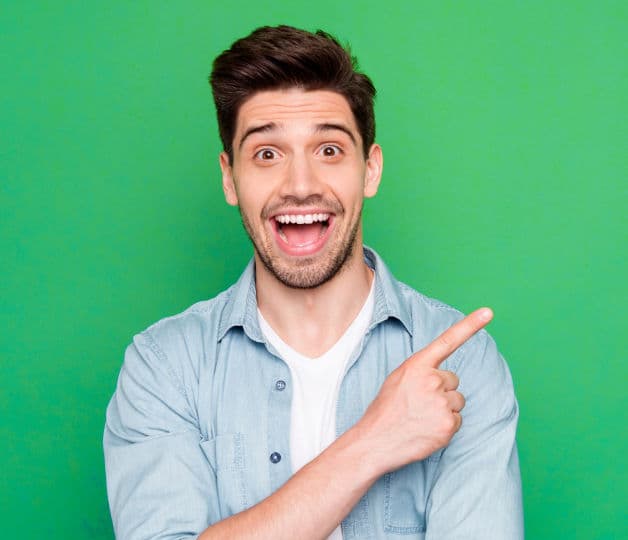 Smiling man in a light blue shirt pointing towards JobsinED testimonials section on a green background.